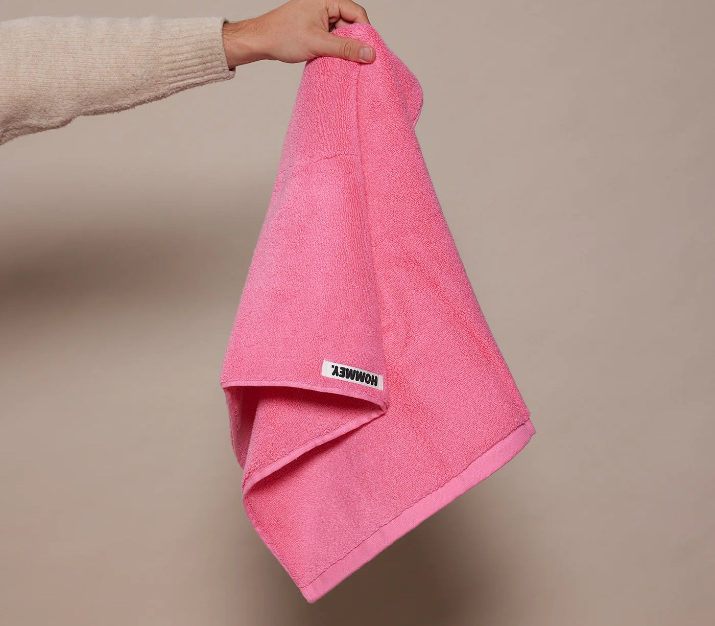 woman holding up pink towel