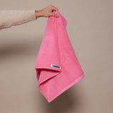 woman holding up pink towel