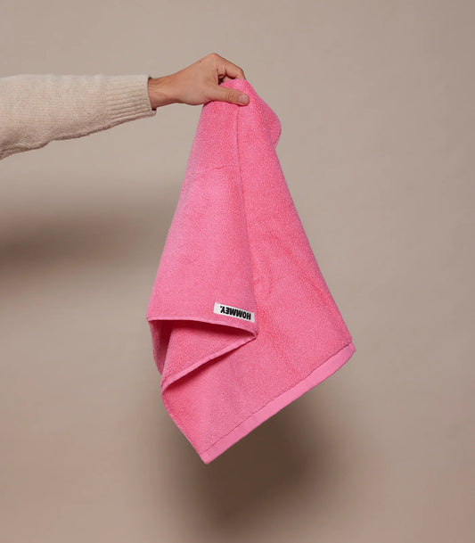 woman holding up pink towel