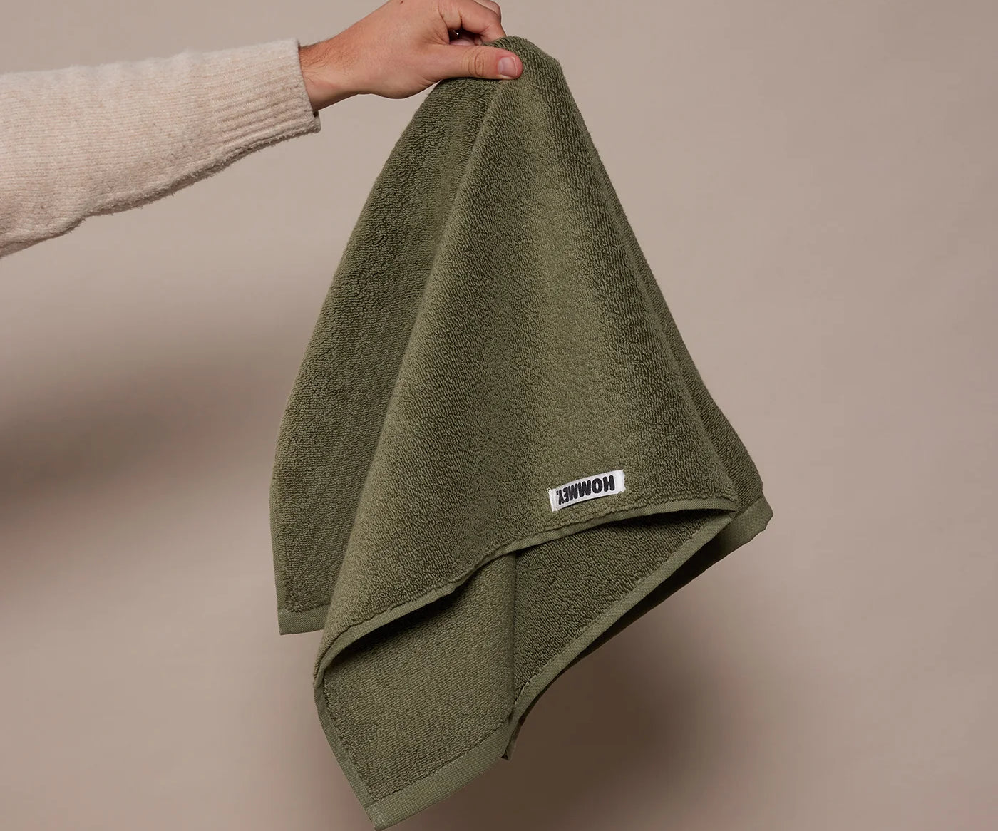  woman holding up a dark green towel