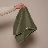  woman holding up a dark green towel