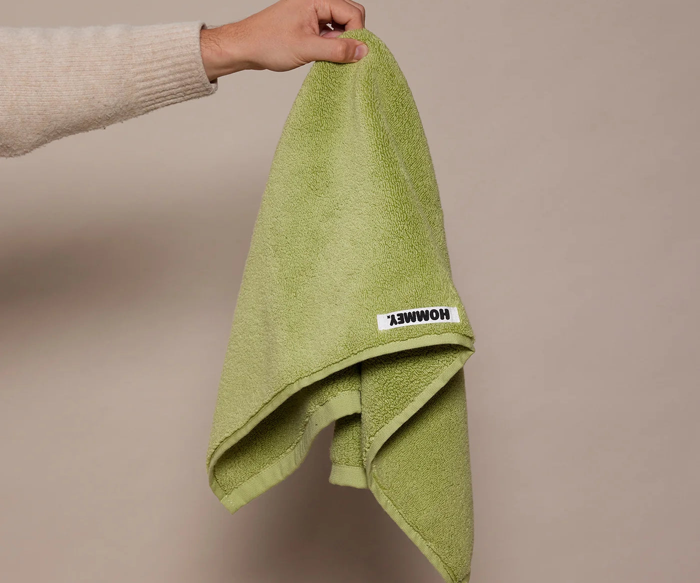 girl holding up green hand towel 