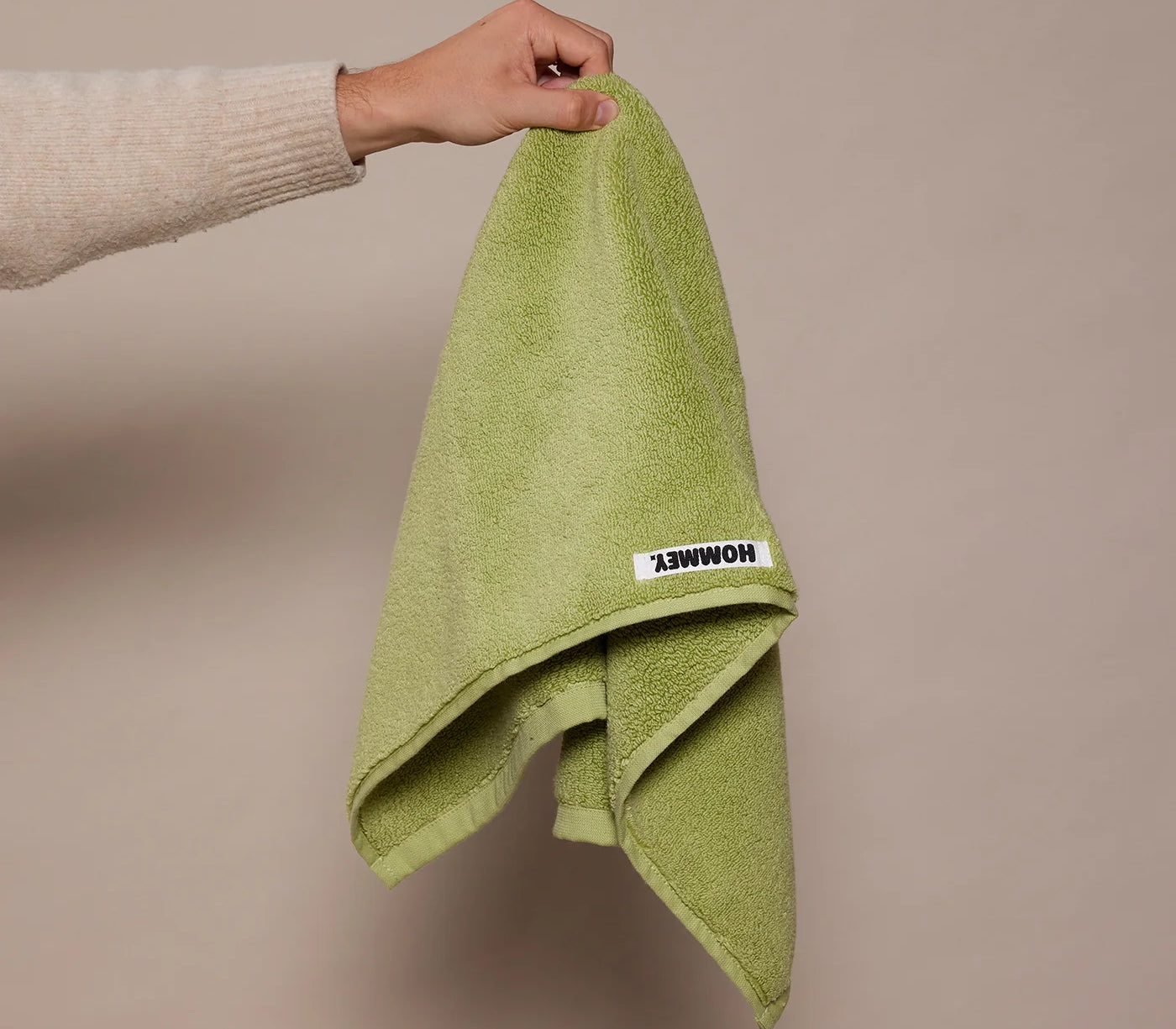 girl holding up green hand towel 
