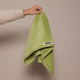 girl holding up green hand towel 