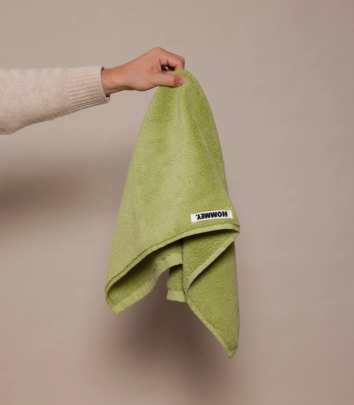 girl holding up green hand towel 