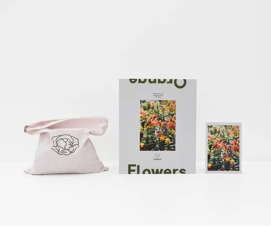 opened up set of a puzzle with orange flowers on it sitting on white background