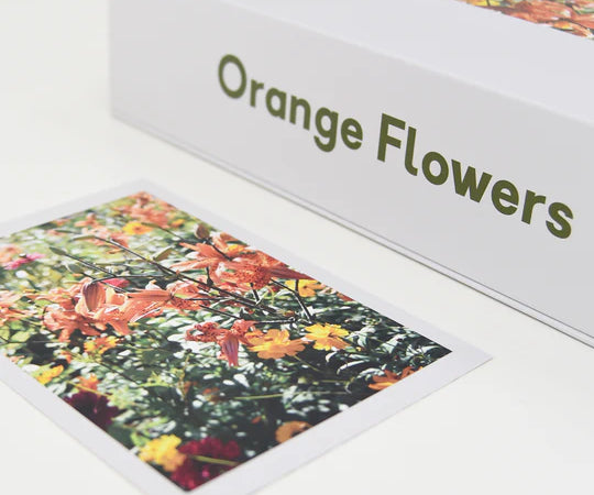 puzzle set of orange flowers lying down on white background with puzzle completed