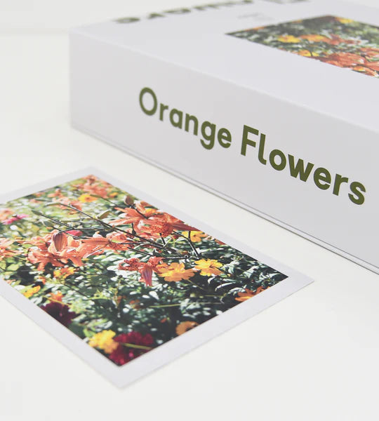 puzzle set of orange flowers lying down on white background with puzzle completed