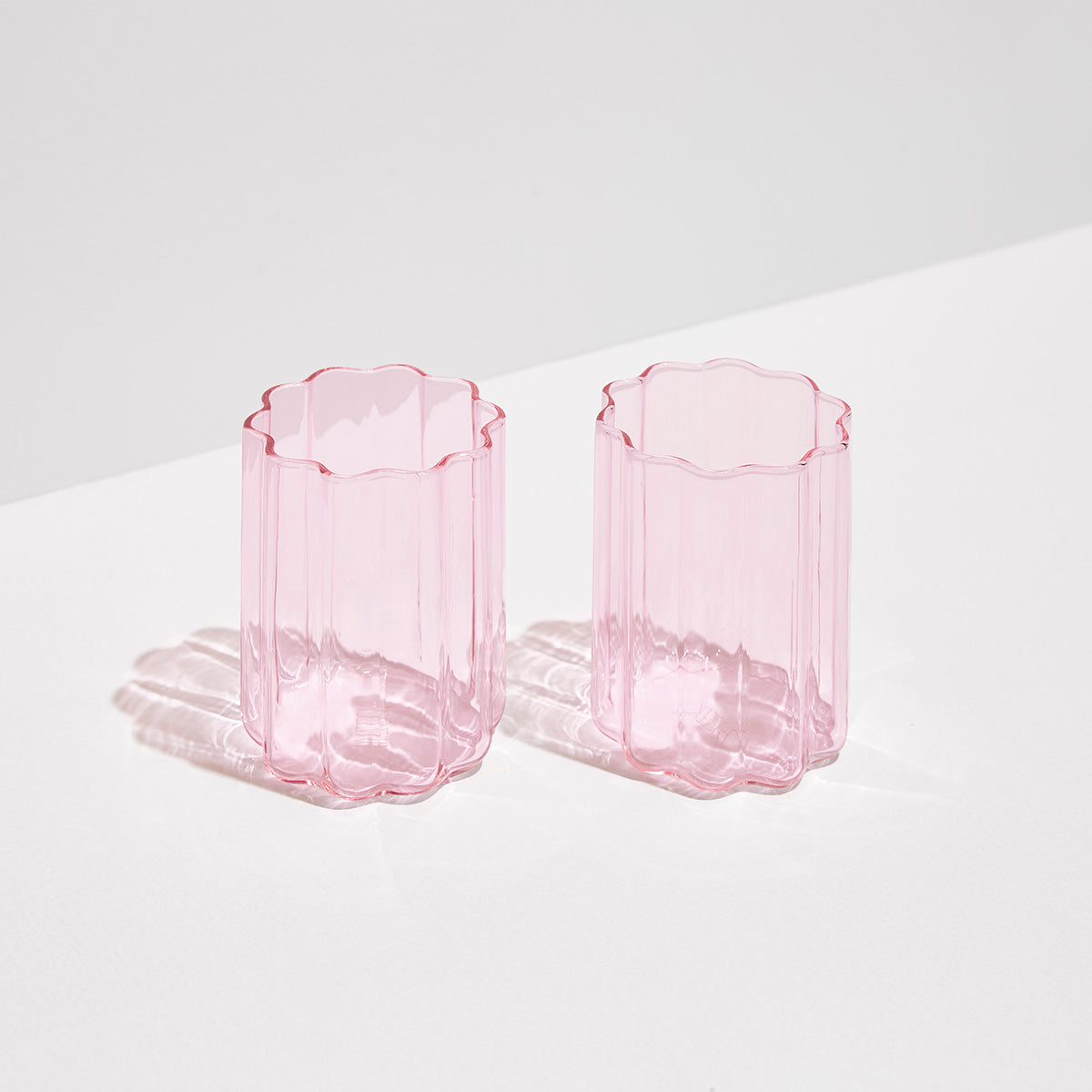 pink wave glasses sitting on white background