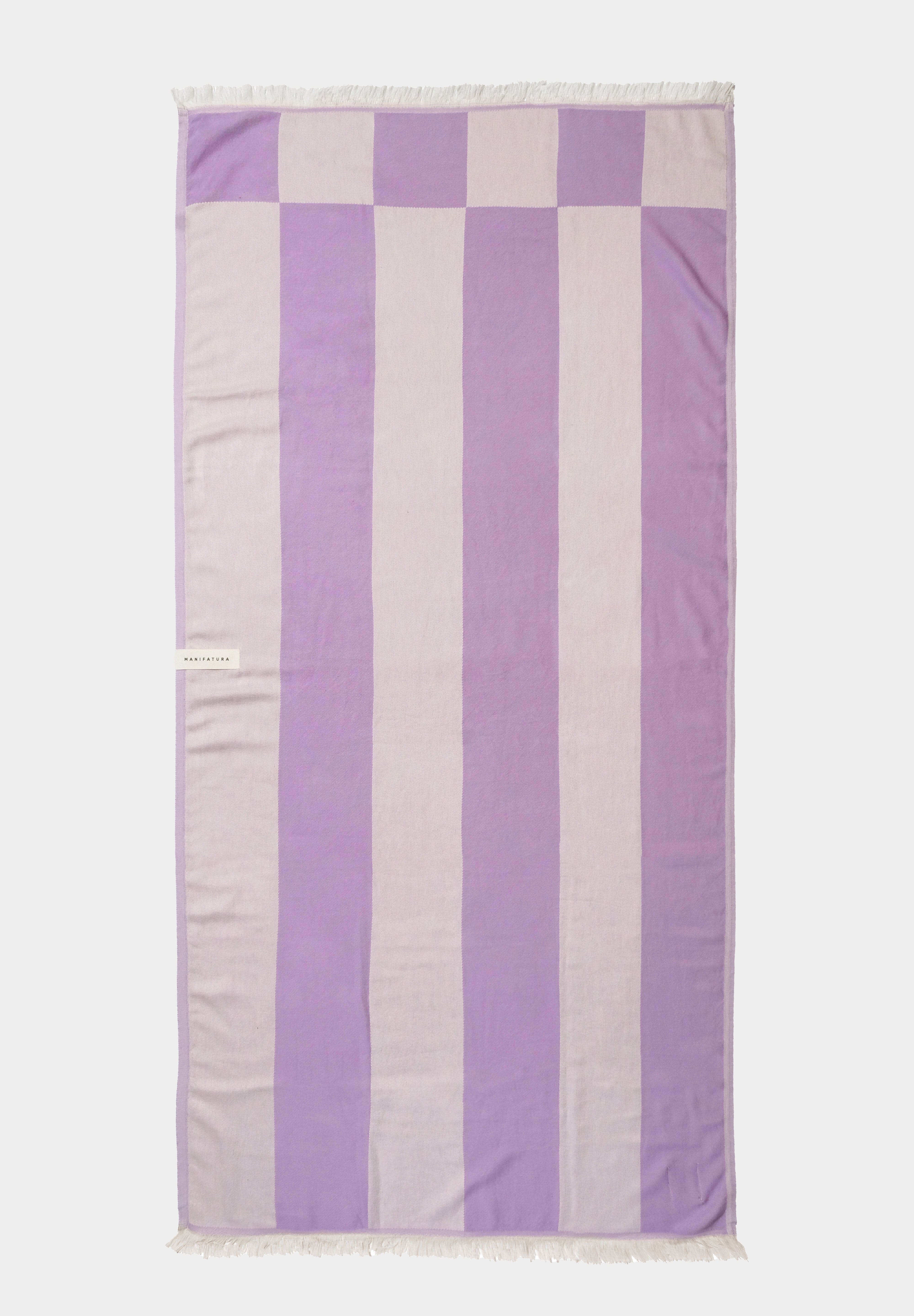 purple beach towel laid out flat