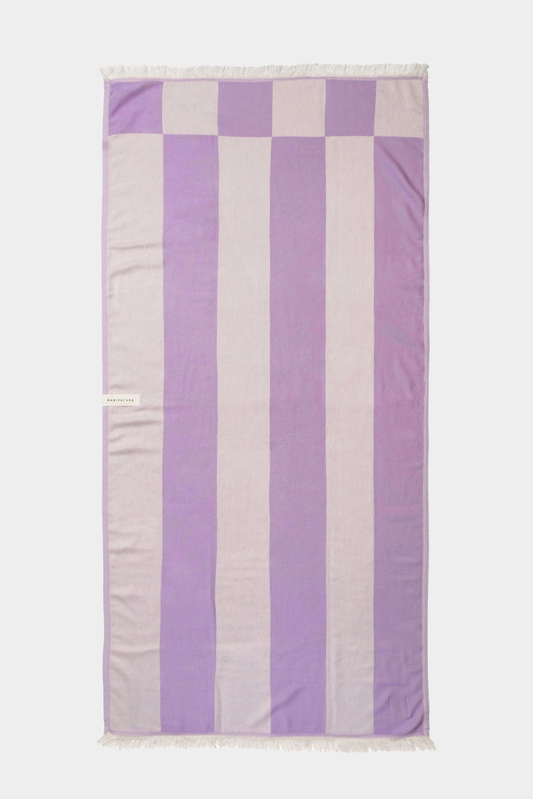 purple beach towel laid out flat