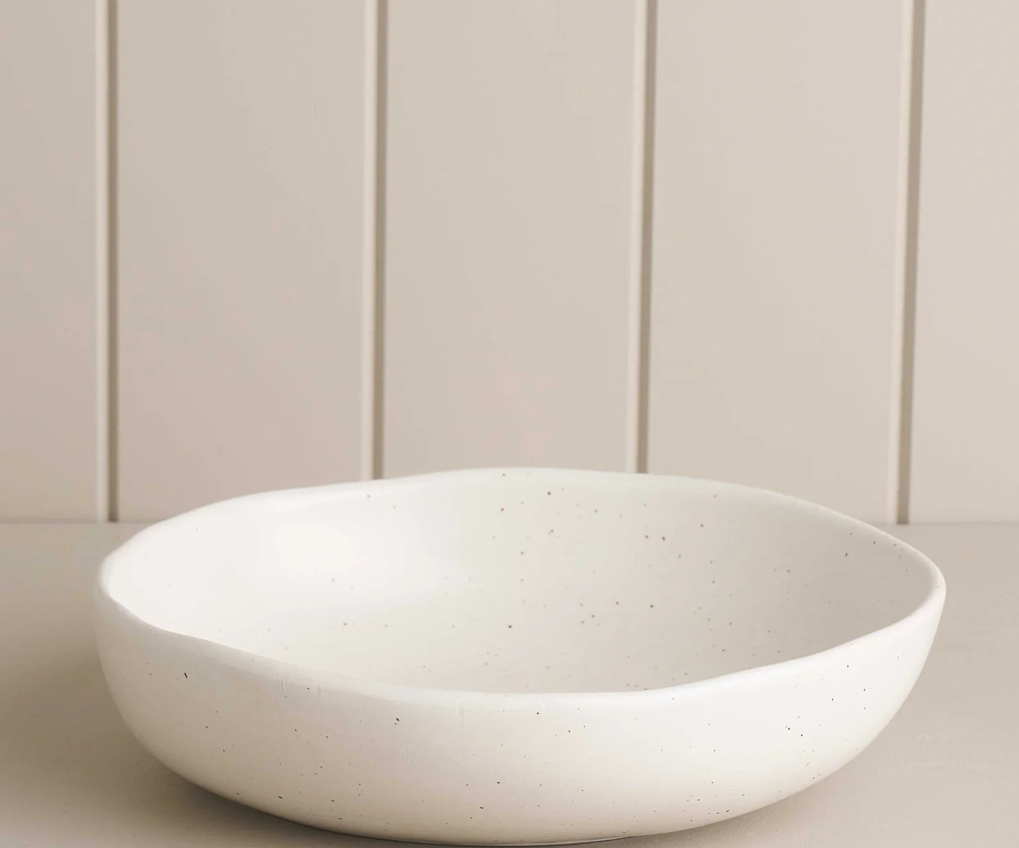 white salad bowl on a wooden shelf 