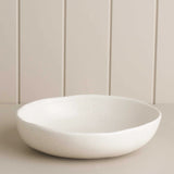 white salad bowl on a wooden shelf 