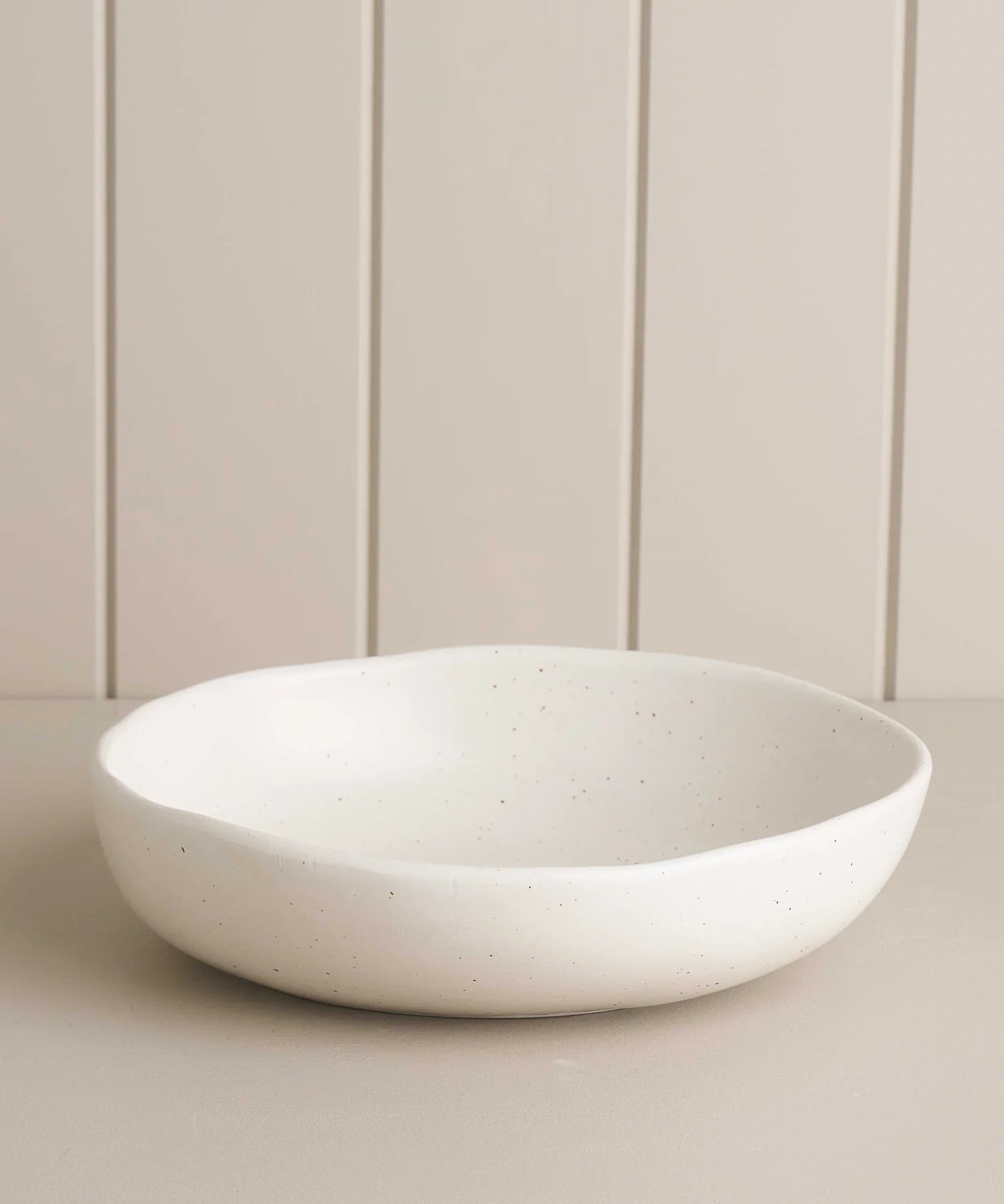 white salad bowl on a wooden shelf 