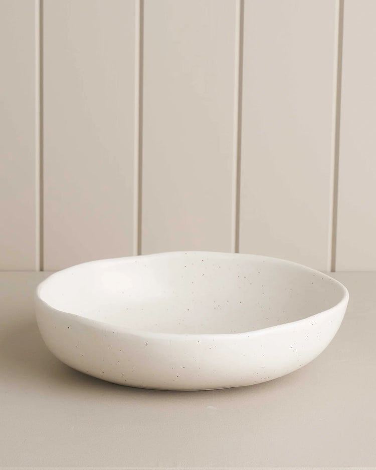 white salad bowl on a wooden shelf 