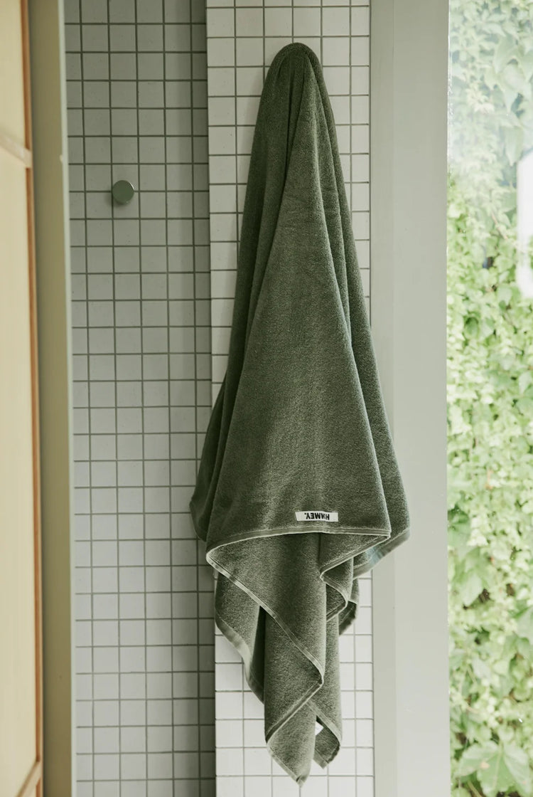 dark green towel hanging up