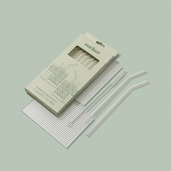 clear glass drinking straws in packaging on green background opened up 