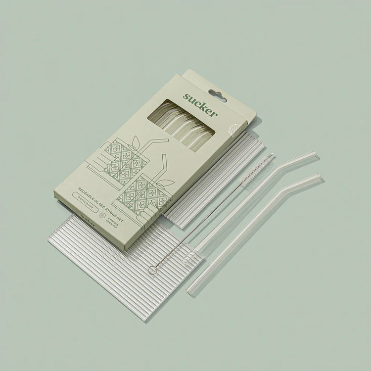 clear glass drinking straws in packaging on green background opened up 