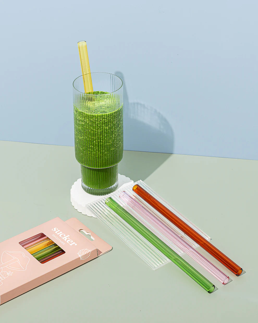 lifestyle shot of straws and smoothie next to them