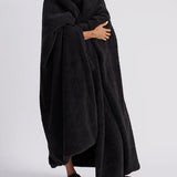 woman standing with black fluffy throw blanket around her