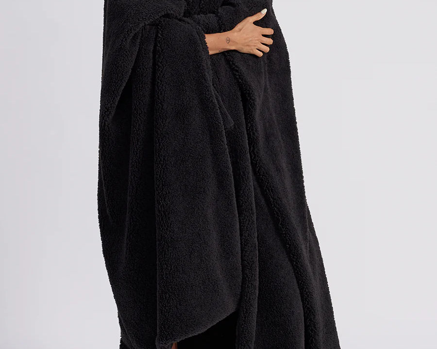woman standing with black fluffy throw blanket around her