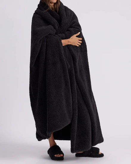 woman standing with black fluffy throw blanket around her