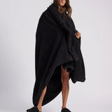 woman standing with black fluffy throw blanket around her