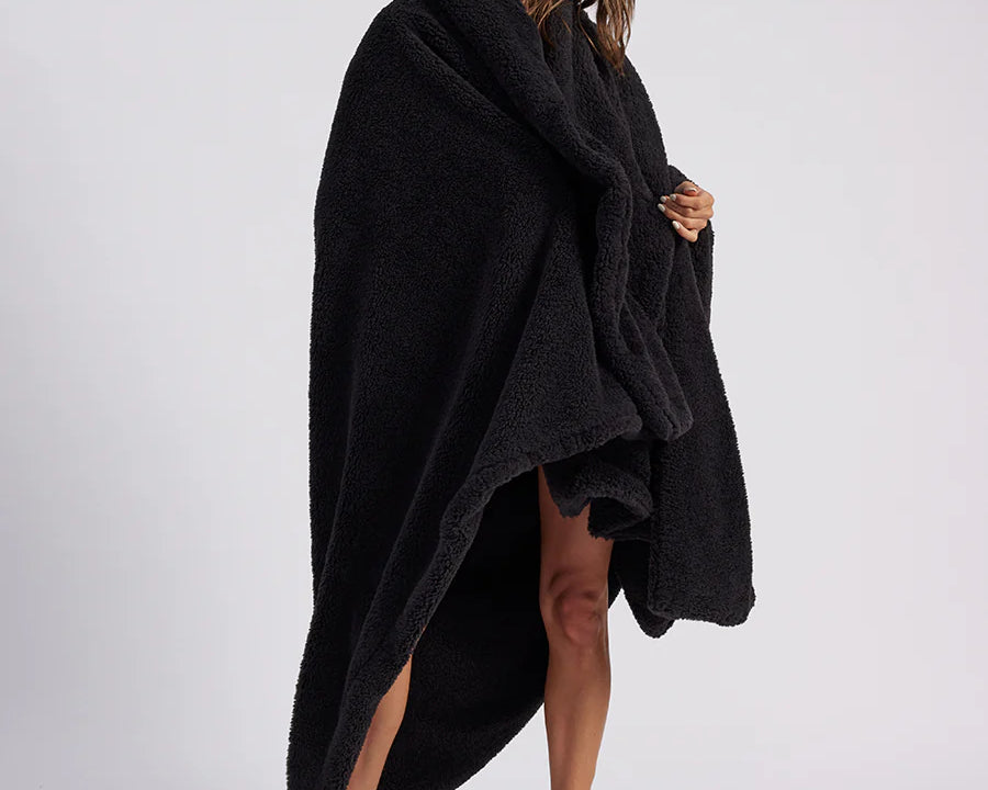 woman standing with black fluffy throw blanket around her