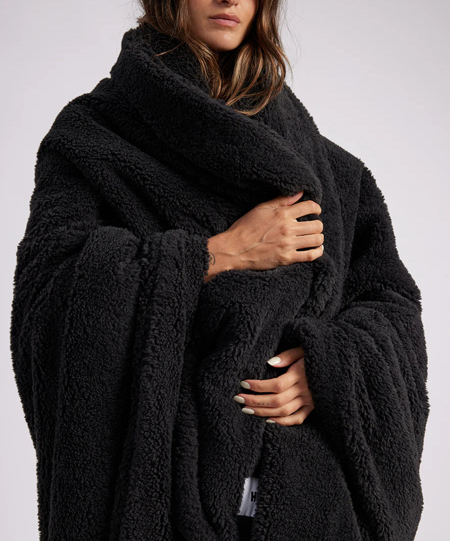 woman standing with black fluffy throw blanket around her