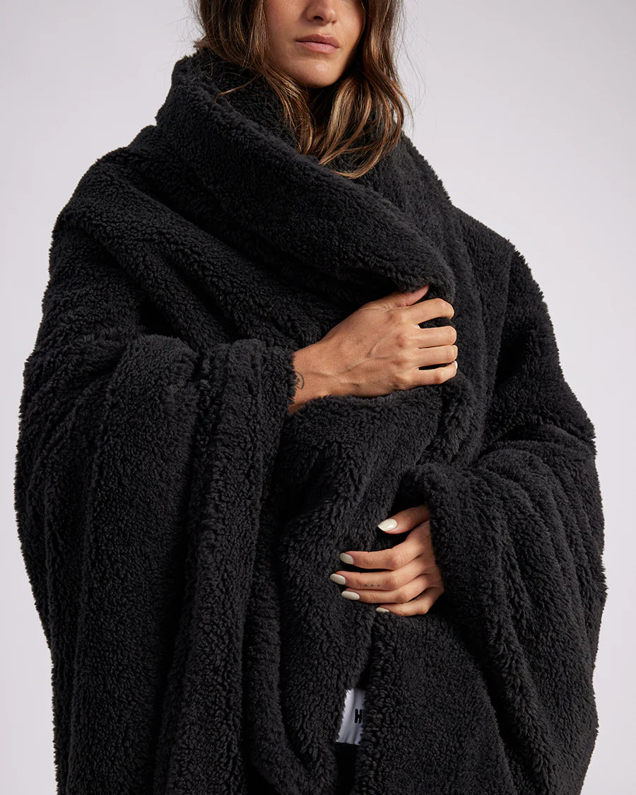 woman standing with black fluffy throw blanket around her