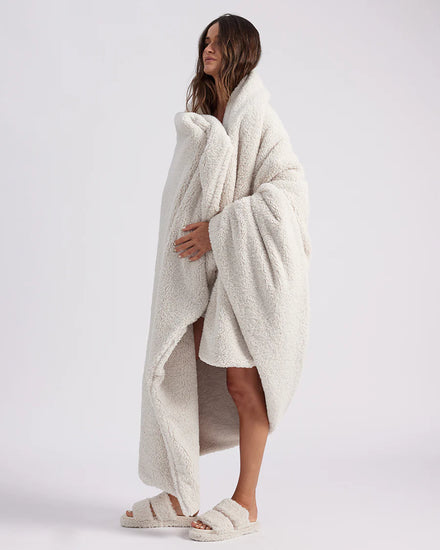 girl wrapped up with a white throw blanket