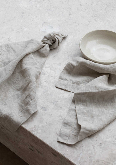 beige linen napkins sitting on a marble table