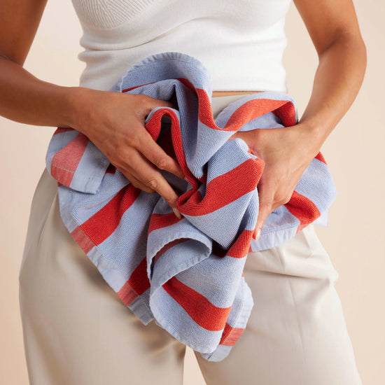 striped red and blue tea towel scrunched up by woman