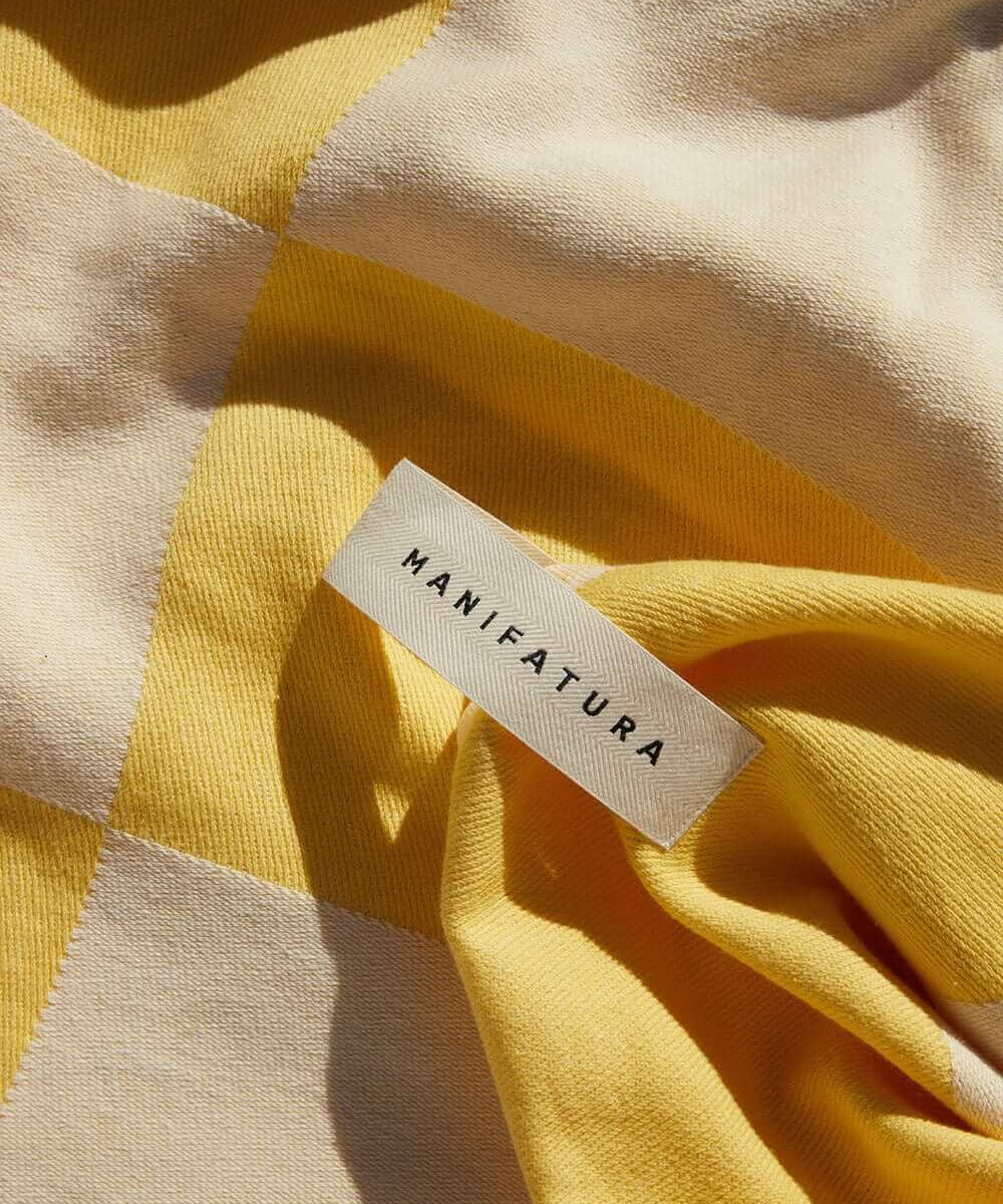 up close picture of yellow and white beach towel
