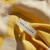 up close picture of yellow and white beach towel