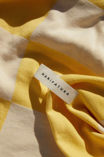 up close picture of yellow and white beach towel