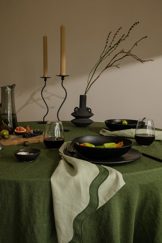 tablescape of food, napkins and other items sitting on table with a green theme