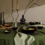tablescape of food, napkins and other items sitting on table with a green theme 