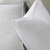 up close picture of white linen cushions sitting on a couch