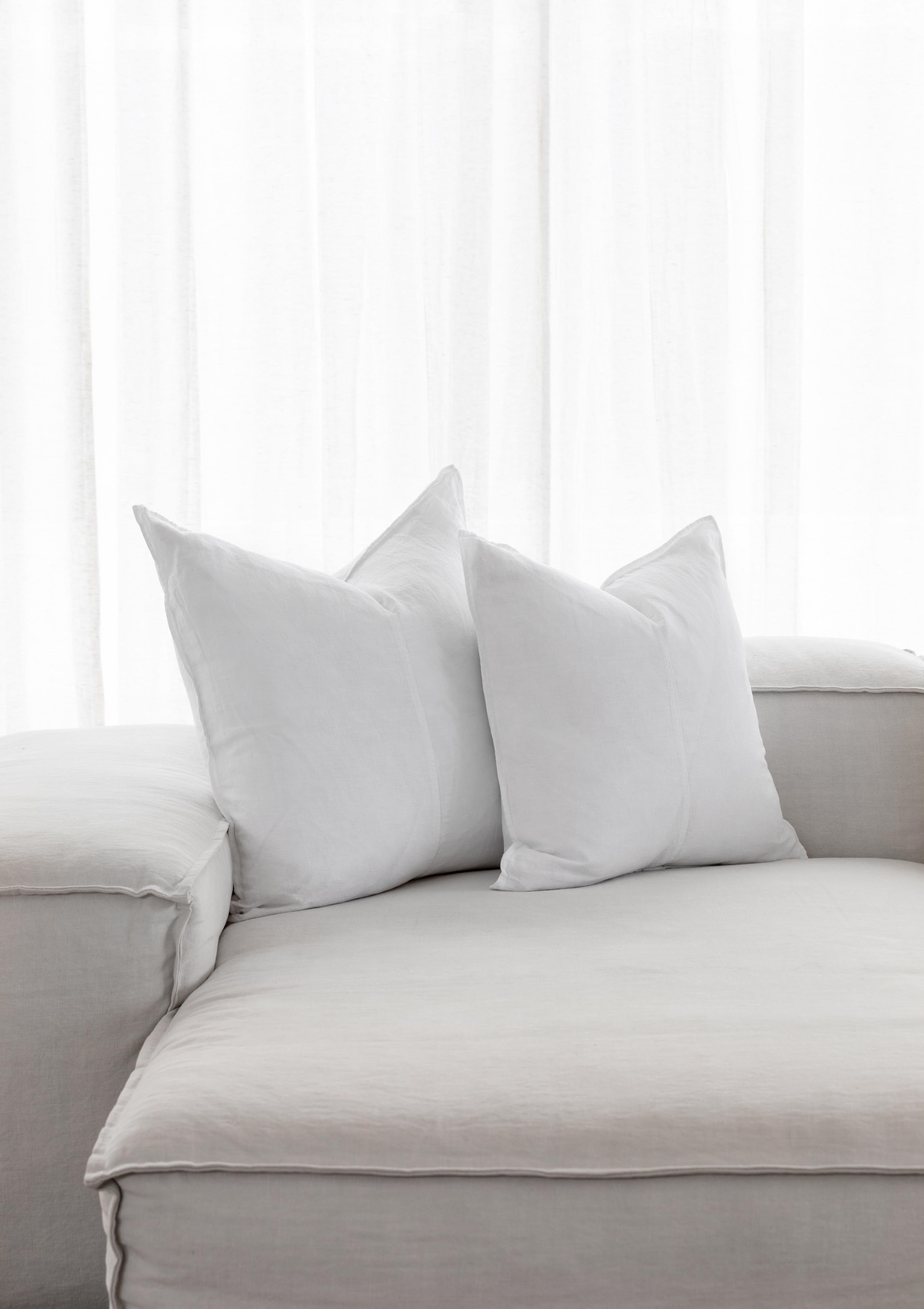 white linen cushions sitting on a couch