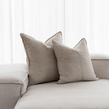 beige linen cushions sitting on white couch