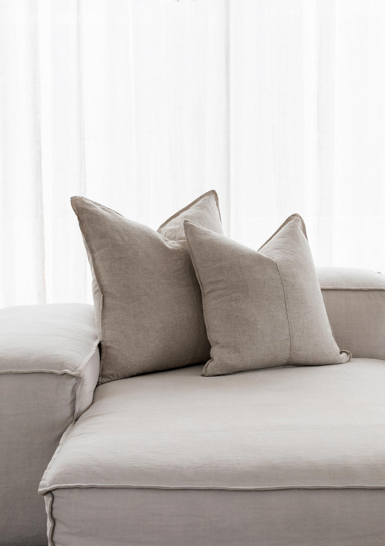 beige linen cushions sitting on white couch