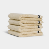 beige face washer towels sitting in a stack on white background