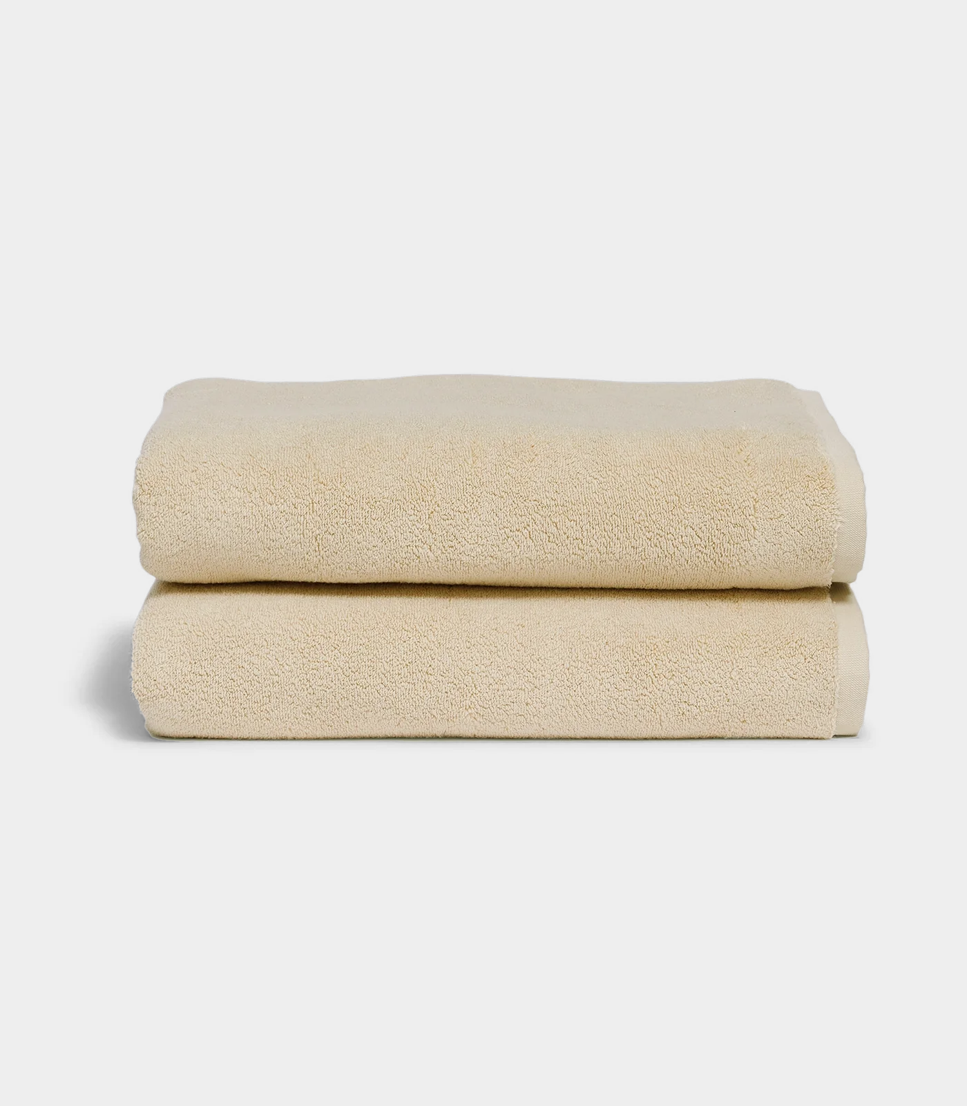 beige towel sitting in stack on white background