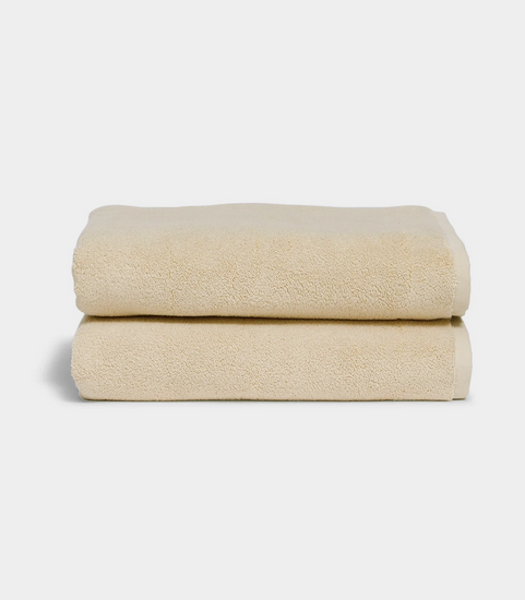 beige towel sitting in stack on white background