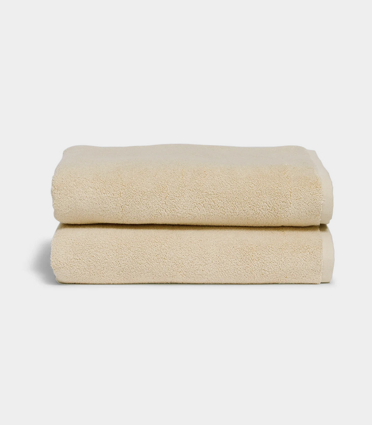 beige towel sitting in stack on white background