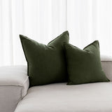 forest green linen cushions sitting on a white couch