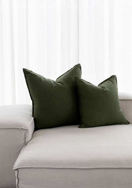 forest green linen cushions sitting on a white couch