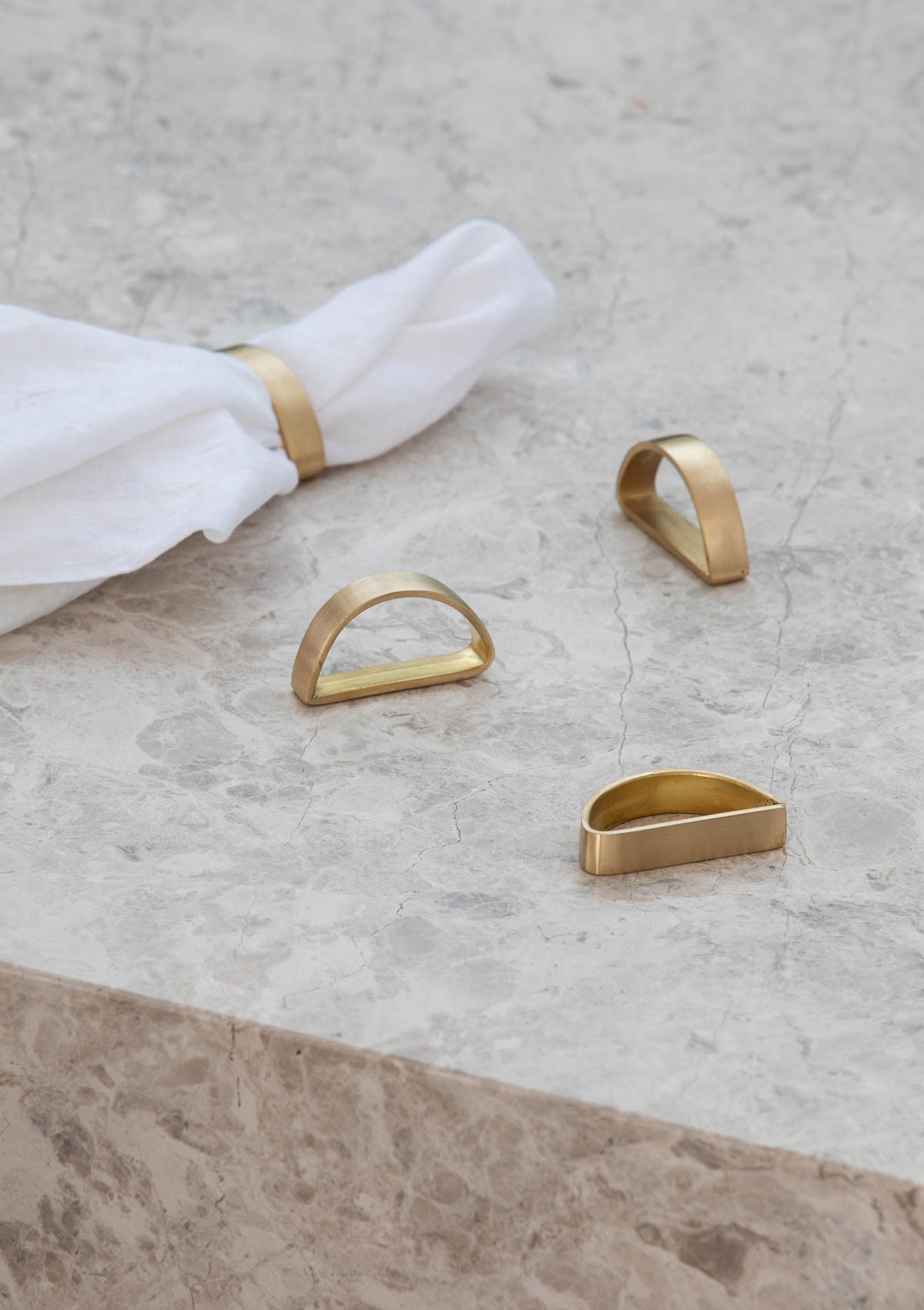 gold napkin rings sitting on a marble table