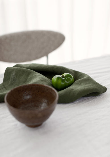 forest green napkins sitting around a bowl on a table